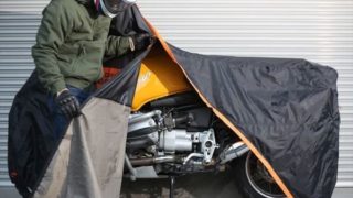 バイクカバーをするライダーの画像