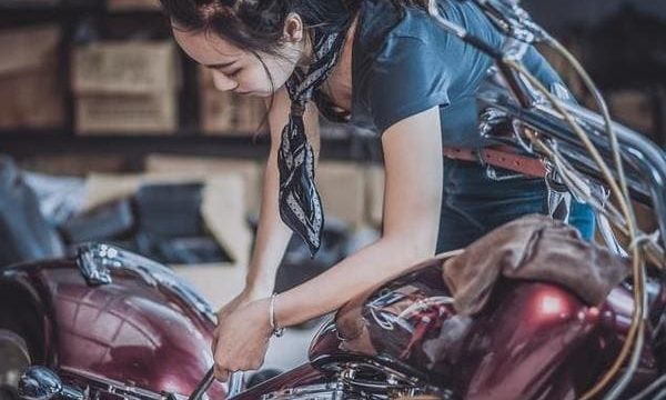 女性がバイクを整備している画像