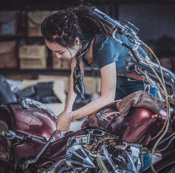 女性がバイクを整備している画像